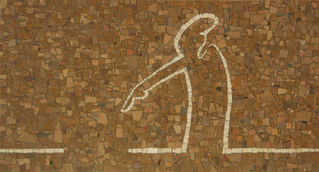 Mosaïque rectangulaire au fond texturé de tesselles de pierre dans des tons terreux (ocre, marron, terracotta), sur laquelle se détache un motif stylisé et épuré en tesselles blanches, évoquant une silhouette humaine 
