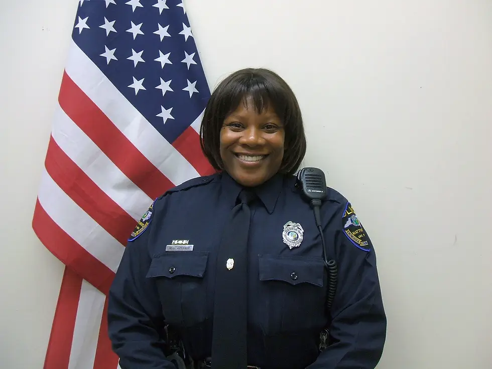 A smiling black female police officer.