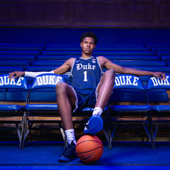 Duke basketball prospect poses in a No. 1 Blue Devils jersey with a basketball inside Cameron Indoor Stadium.