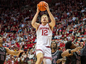 Tucker DeVries of the Indiana Hoosiers attempts a layup while being guarded during a college basketball game.