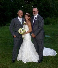 Wedding Officiant Sal Fiore takes a picture  with his couple after their ceremony.