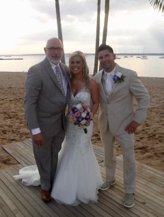 Sal Fiore takes a picture with a married couple on the beach