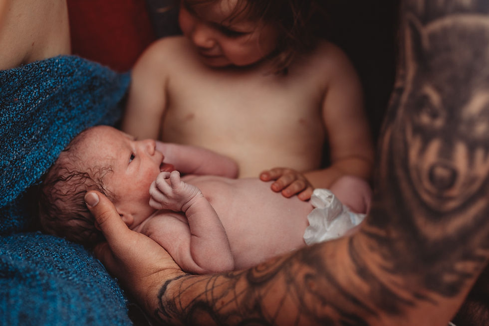 schwester-haelt-baby-bruder-zum-ersten-mal-nach-der-geburt