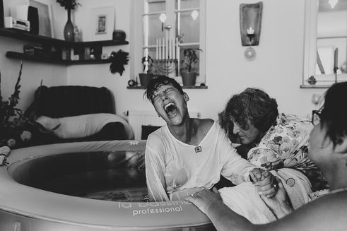 gebaerende-bei-hausgeburt-im-pool-mit-hebamme-geburtsfotografie