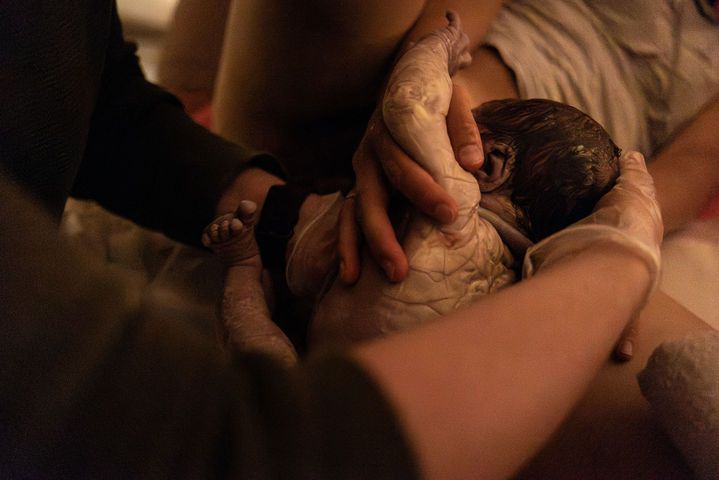 baby-wird-mit-kaeseschmiere-geboren-mit-hebamme-geburtsfotografie