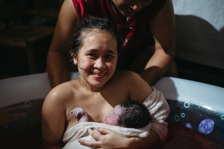 mutter-haelt-neugeborenes-baby-und-strahlt