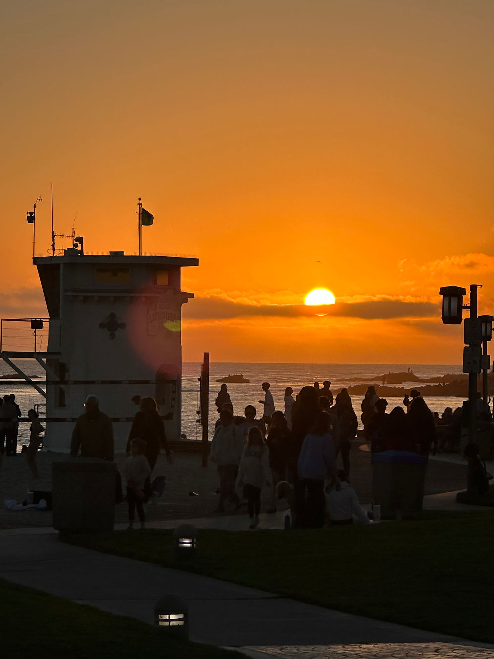 Sunset with orange sky behind lifeguard tower at the beach