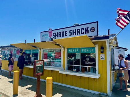 A yellow cottage with a large sign that reads: "Crystal Cove Shake Shack."