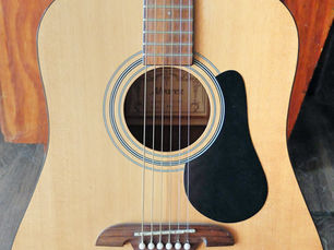 Acoustic guitar labeled with its main parts, introducing the basic components every beginner guitarist should know.