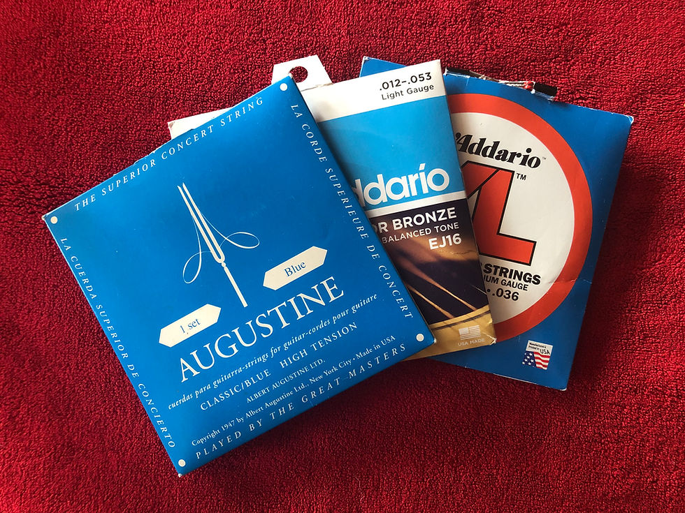 Packages of electric guitar strings, steel-string acoustic guitar strings, and classical nylon guitar strings, showing the different string types used for each instrument.