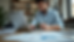 Eye-level view of a small business owner reviewing financial documents at a desk