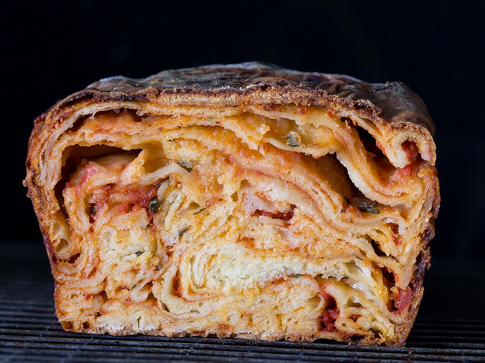 Scaccia A street food popular in its native Ragusa, scaccia is an exercise in rustic simplicity: A pizza-style dough is rolled super-thin, smeared with tomato sauce, showered with D.O.P. caciocavallo cheese, and folded into a lasagna-like loaf.