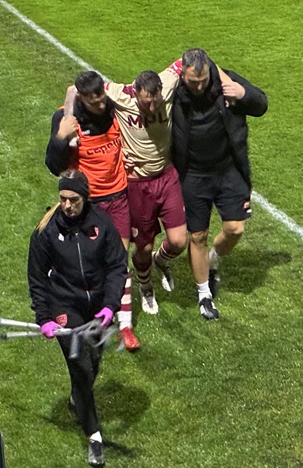 Brad Carroll assisted off the field by Billy Redden and Louis Jacobs