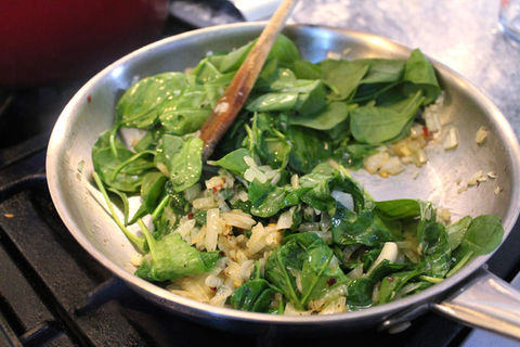 Spinach and onions sautéing in a pan