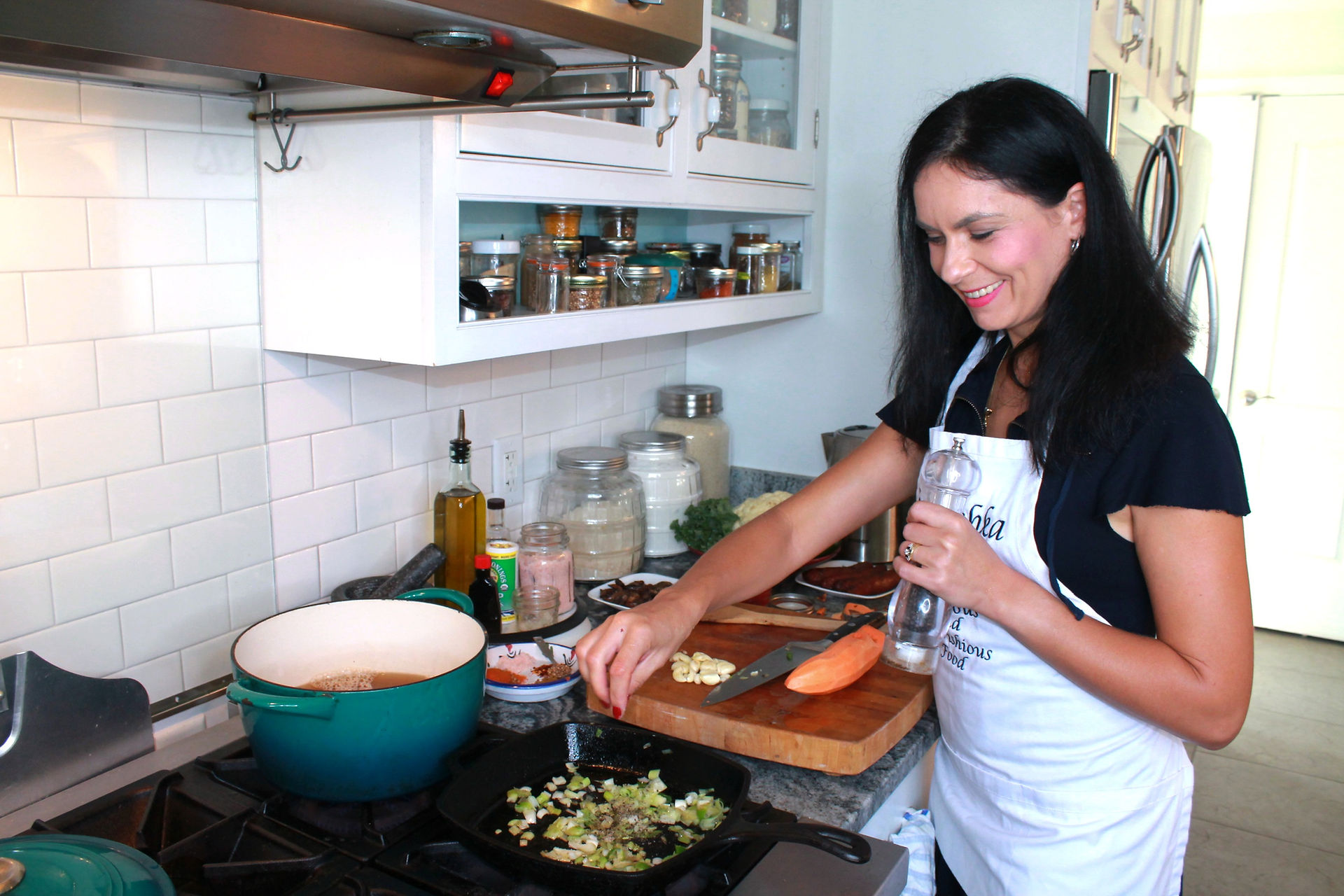 Woman sprinkling salt on green onions cooking on the stovetop