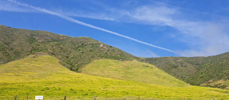 A beautiful view of green central California hills and a slightly cloudy, mostly blue sky.