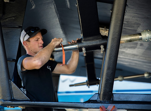 Regular maintenance is worth the time. Poor maintenance can mean disaster later. Crew member performs vessel maintenance in a boatyard.