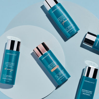 Four Colorescience Sunforgettable Total Protection Face Shield SPF 50 bottles in Bronze, Flex, Glow, and original formulas arranged on a light blue background, recommended by Herasme Beauty