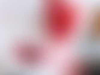 Michelle Herasme, Board-Certified Nurse Practitioner and founder of Herasme Beauty, standing in her Englewood, NJ studio decorated with red heart balloons and Valentine's Day gifts including wine, wrapped presents, and heart decorations