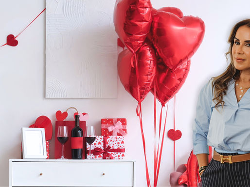 Michelle Herasme, Board-Certified Nurse Practitioner and founder of Herasme Beauty, standing in her Englewood, NJ studio decorated with red heart balloons and Valentine's Day gifts including wine, wrapped presents, and heart decorations