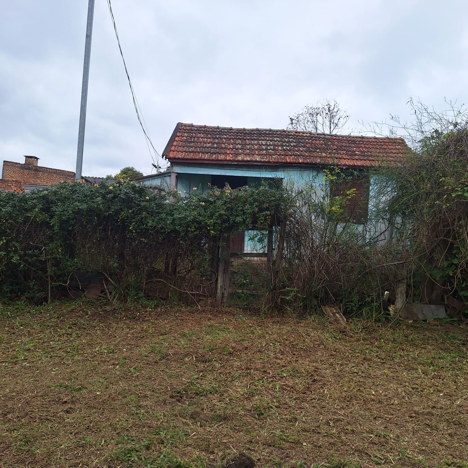 VENDE-SE TERRENO COM CASA DE MADEIRA na Rua Adolfo Luchesi, 159