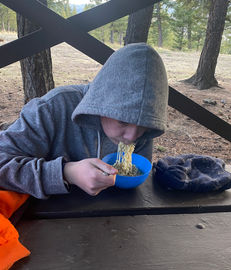 Person enjoying noodles outdoors