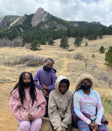 Four students wearing masks on a hike