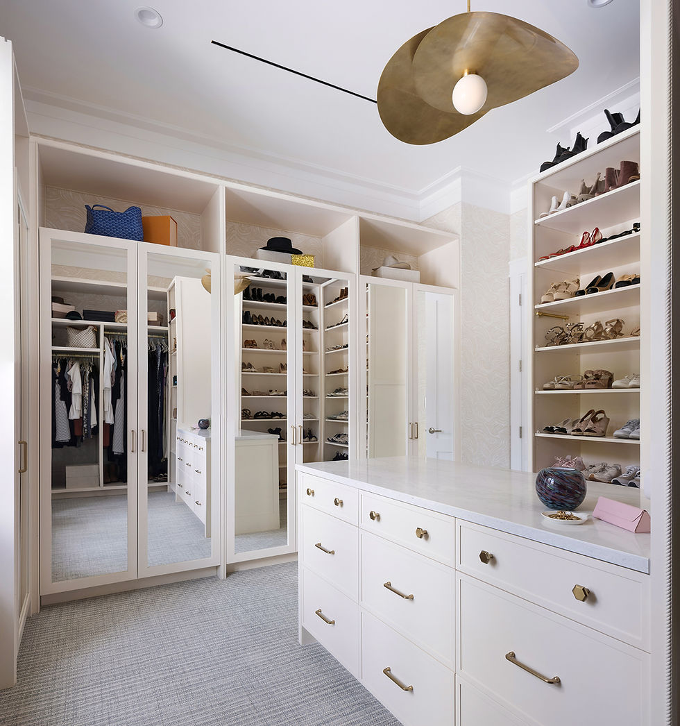 Large walk-in closet with custom cabinetry and lighting in a luxury custom home