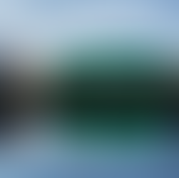 A photo of the Hydro in Glasgow at dusk or dawn, with a reflection in the river