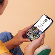 A girl looking at a mobile phone showing Jo Weston's tiktok profile