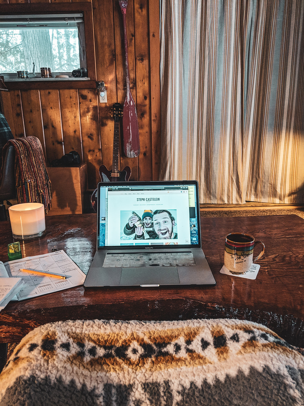 A cabin scene with my computer and calendar working on blog traffic and views.