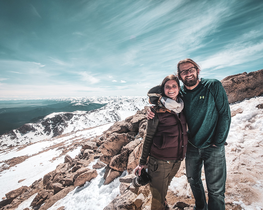 Steph and Scott from Each Day Slow take a picture at the top of Mt. Evans in Colorado celebrating one year of marriage.