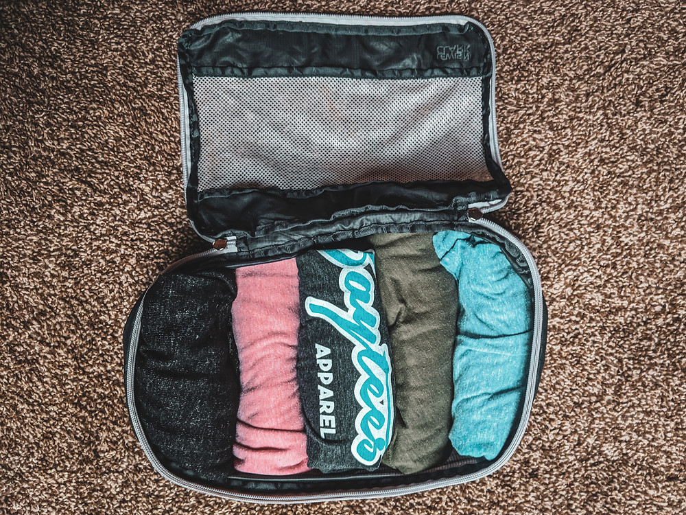Steph from the Each Day Slow blog recommending rolling your clothes while packing as a travel hack.