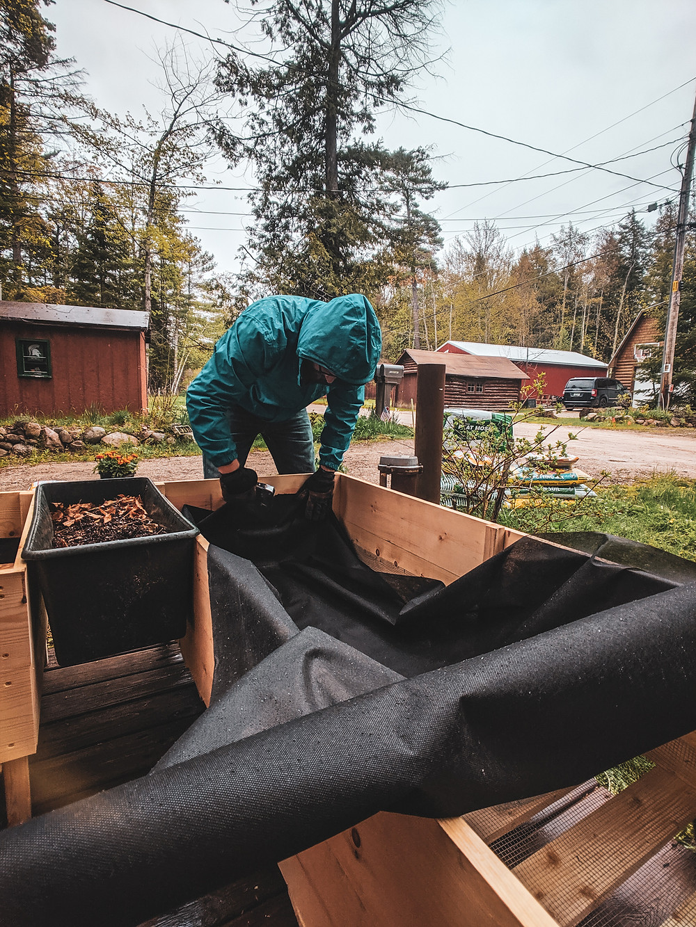 Attaching the weed control fabric to our DIY raised garden beds in Northern Michigan designed by Steph Castelein at the Each Day Slow blog.