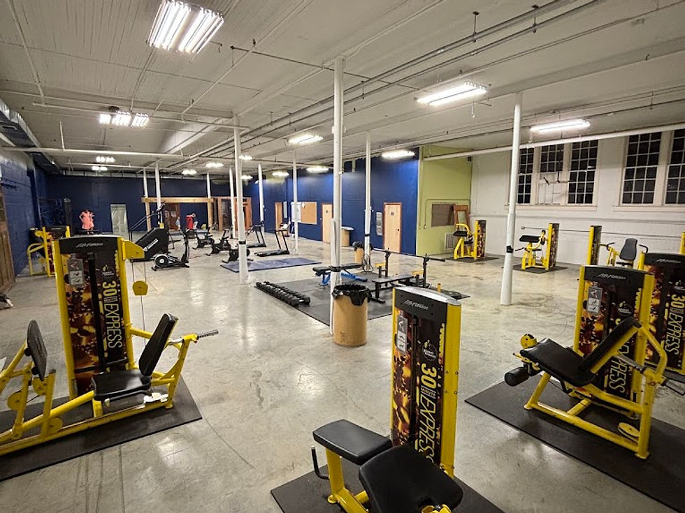 Wide landscape photo of Old Skool Gym interior showing yellow strength machines spaced across a large open 4400 sq ft training floor