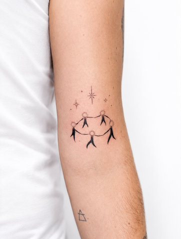 Fine-line constellation tattoo connecting stars in a geometric pattern on the arm