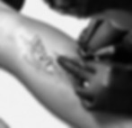 Close-up of a tattoo artist working on a fine line forearm piece