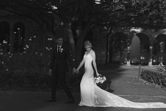 Creative black and white photo of couple walking along roses