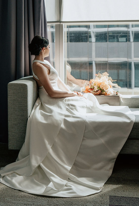 Bride laying by window with light shining on her