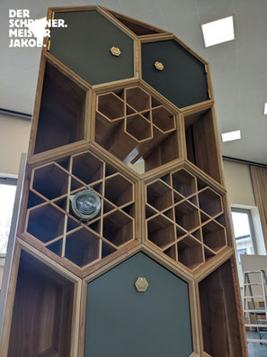 Das Bild zeigt ein aus Holzwaben gebautes Möbel. Zu sehen sind Elemente mit Türen, Schubkästen, aber auch Elemente in denen Einmachgläser gelagert werden können