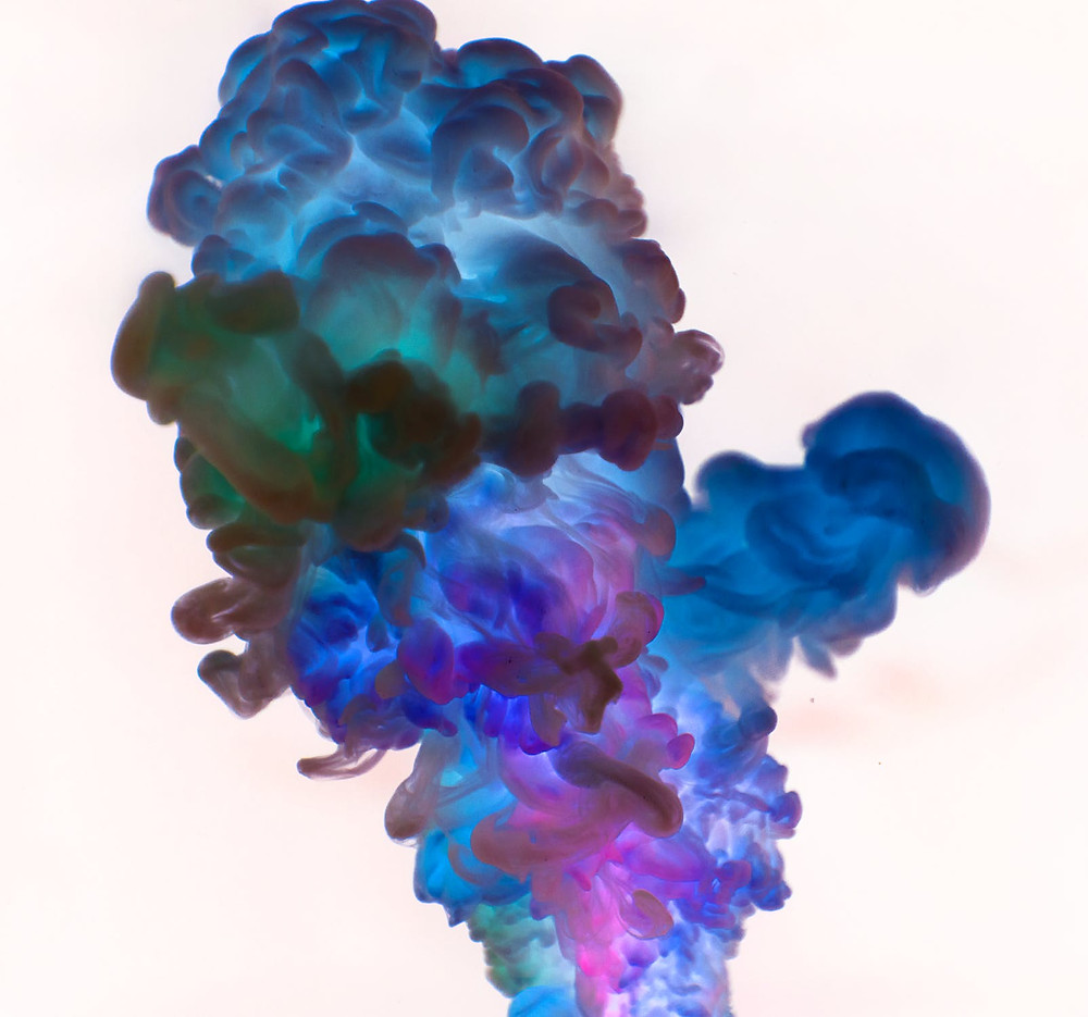 multicolored smoke rising on light pink backdrop