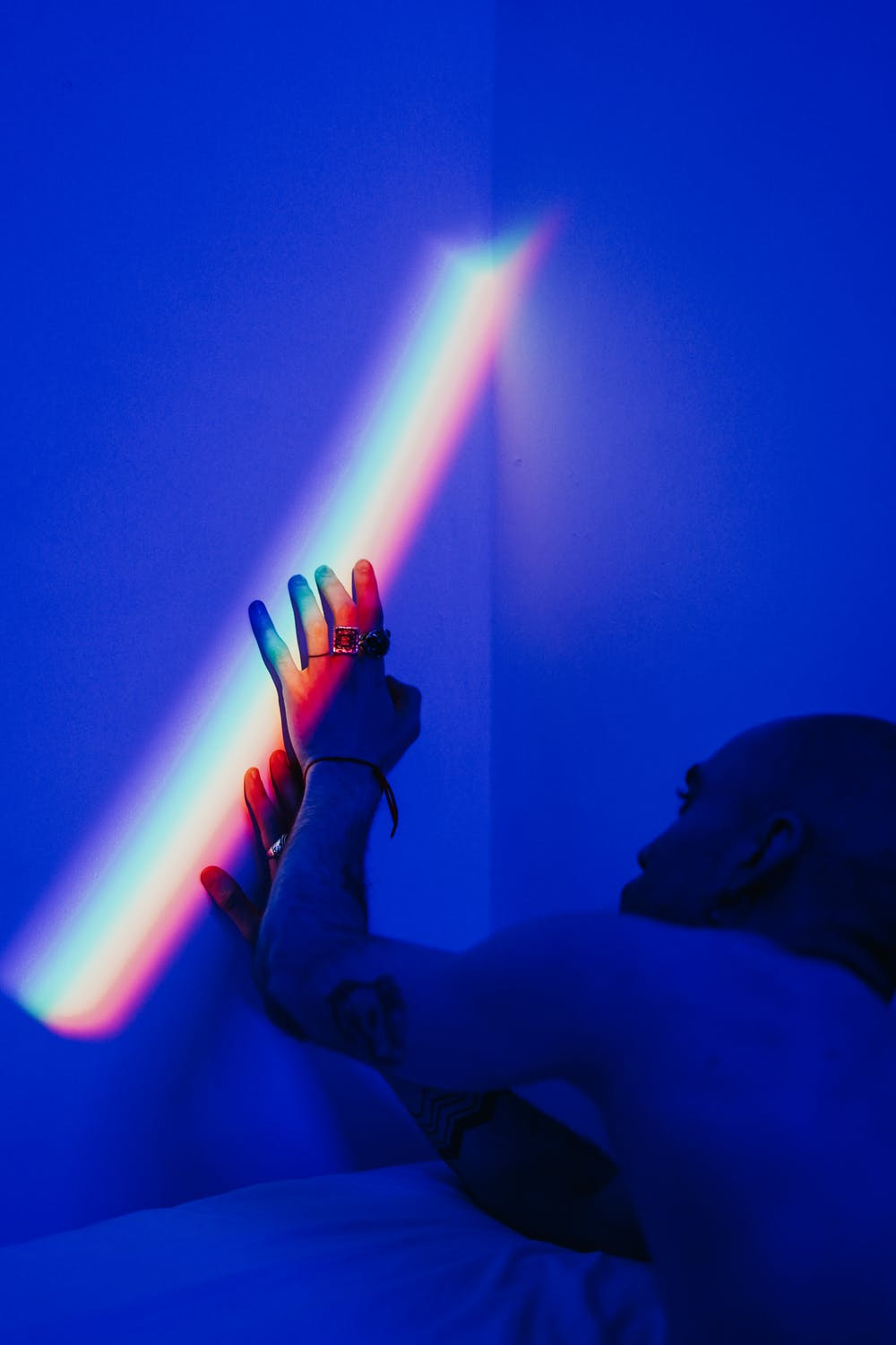 man reaching for rainbow in blue bedroom