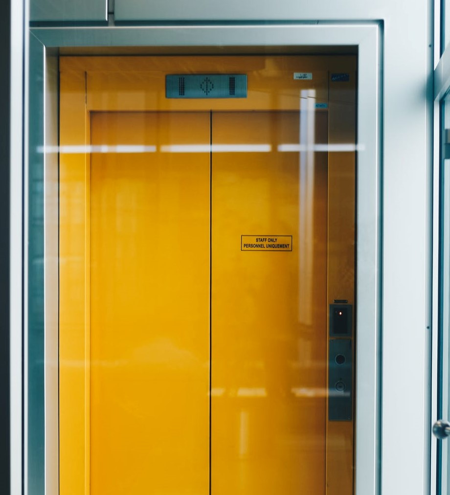 yellow elevator with glass in front