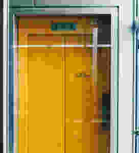 yellow elevator with glass in front
