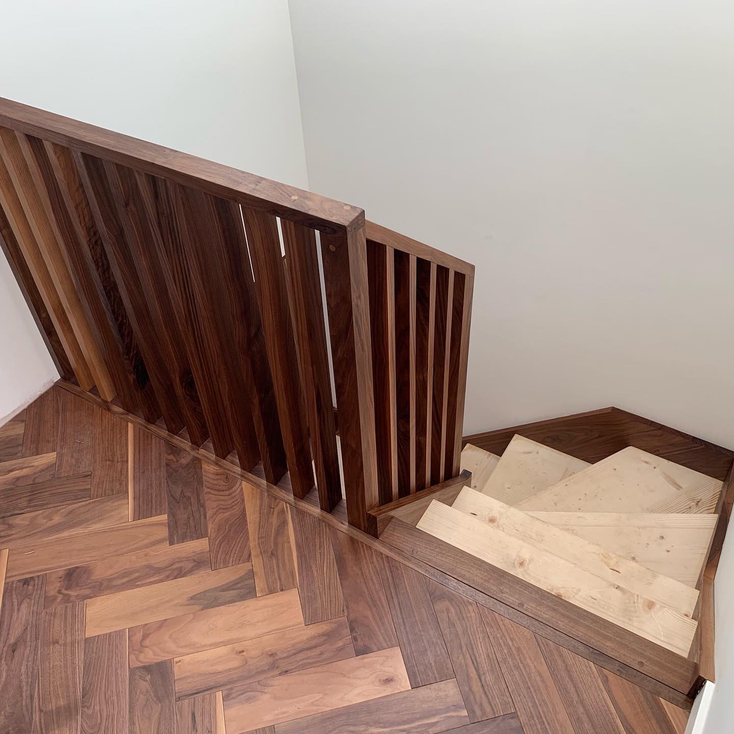 Walnut string staircase with full height walnut spindles