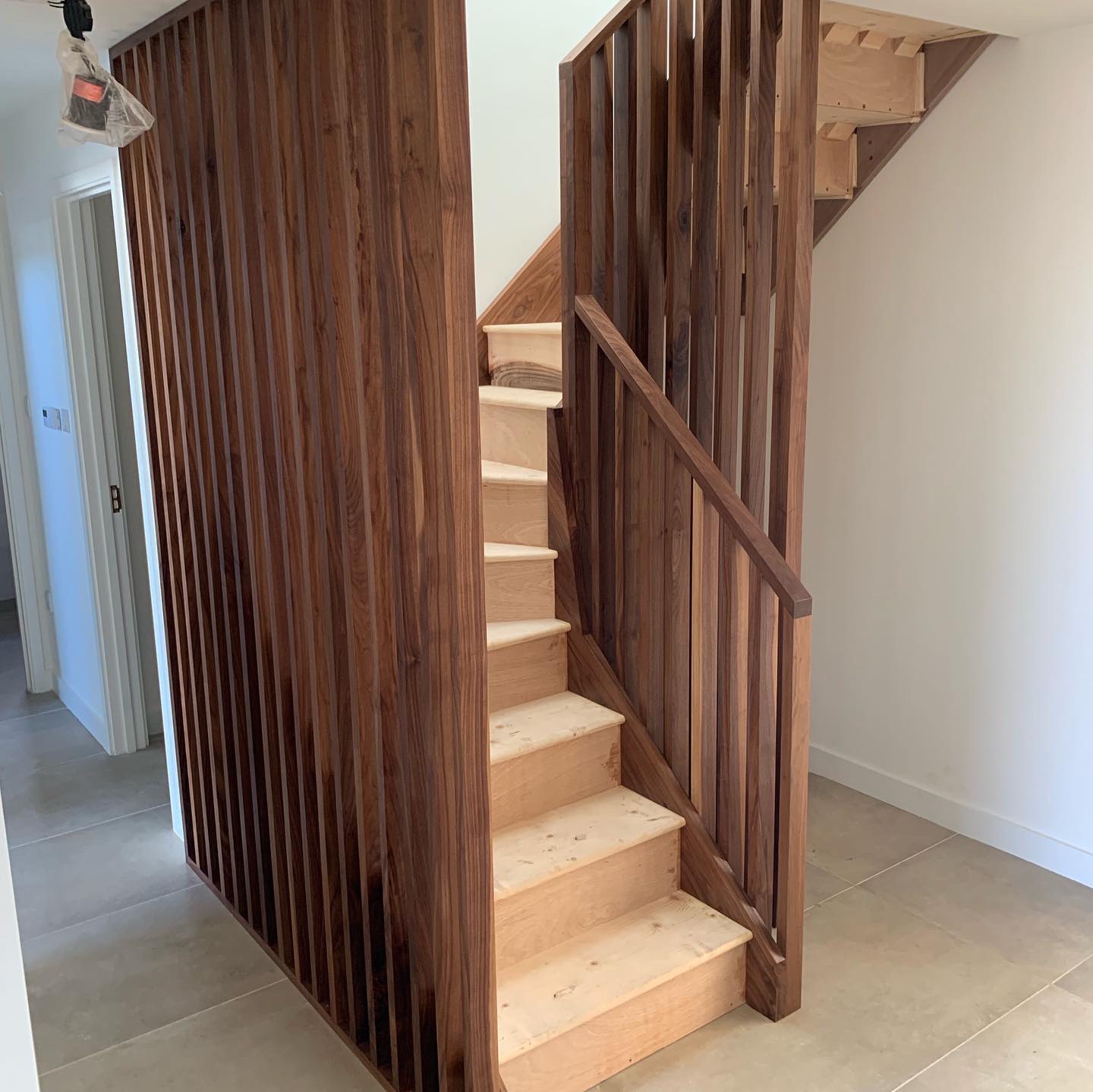 Walnut string staircase with full height walnut spindles