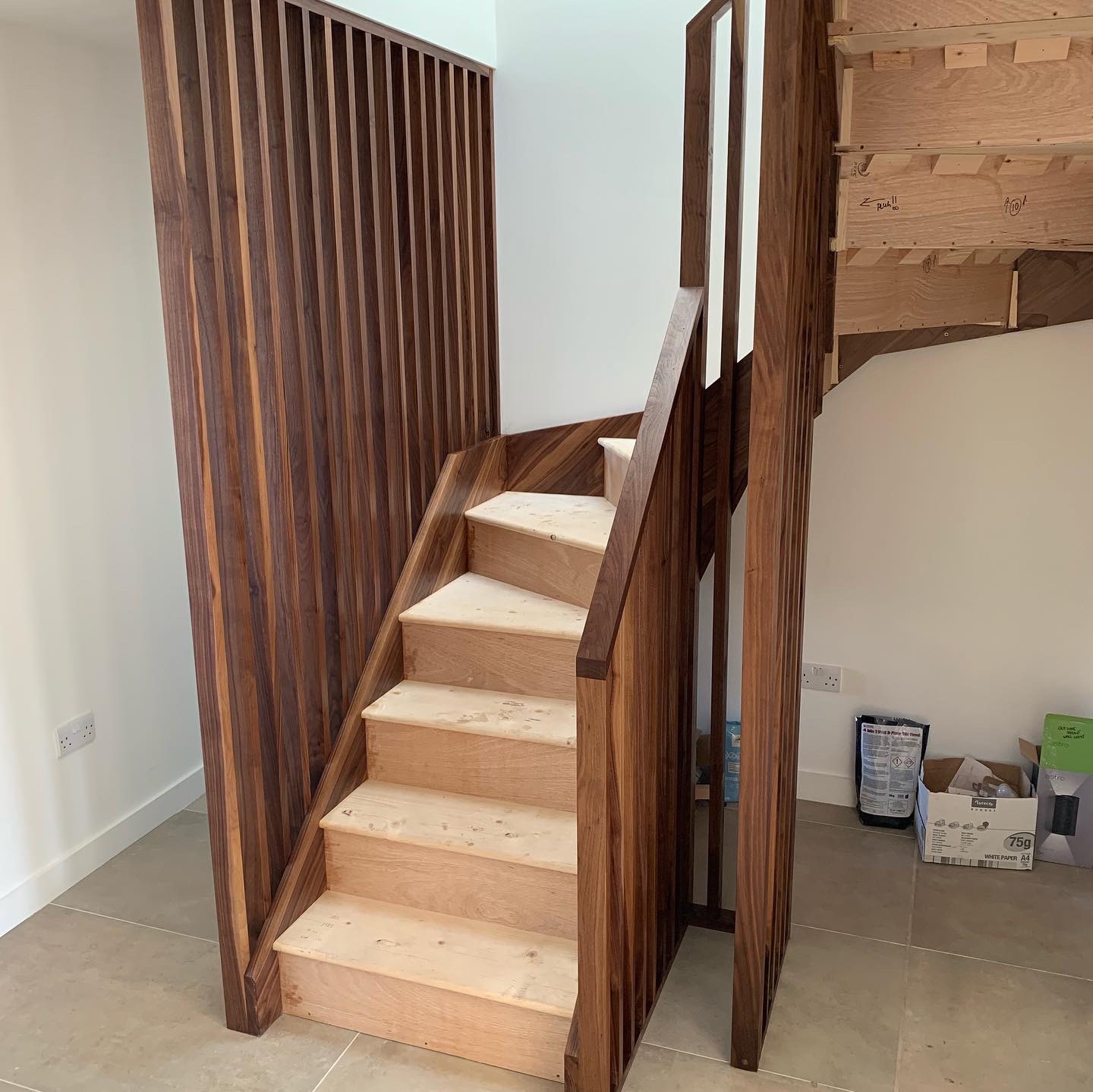 Walnut string staircase with full height walnut spindles
