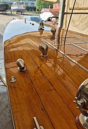 Varnished wooden boat deck with chrome fittings