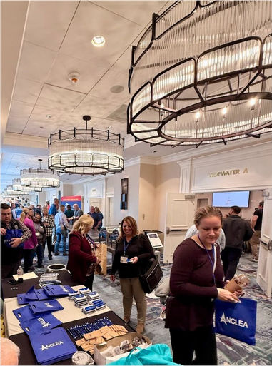 Sponsor tables in the hallway with many people walking around