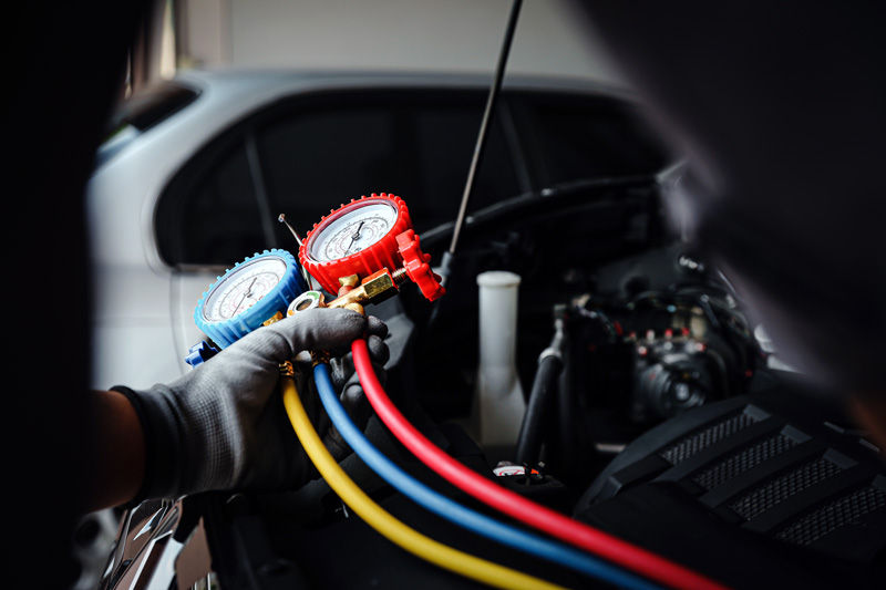 mechanic technician use meter to check car a/c and heating system